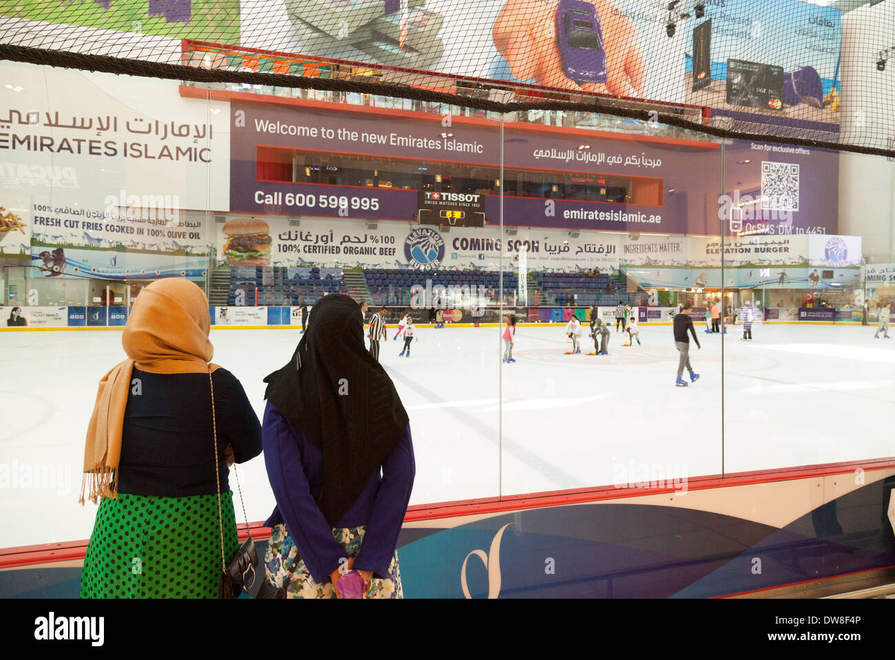 Zwei muslimische Frauen Leute skaten zu beobachten; die Dubai Mall Eisbahn, Dubai Mall, Dubai, Vereinigte Arabische Emirate, Vereinigte Arabische Emirate Naher Osten Stockfoto