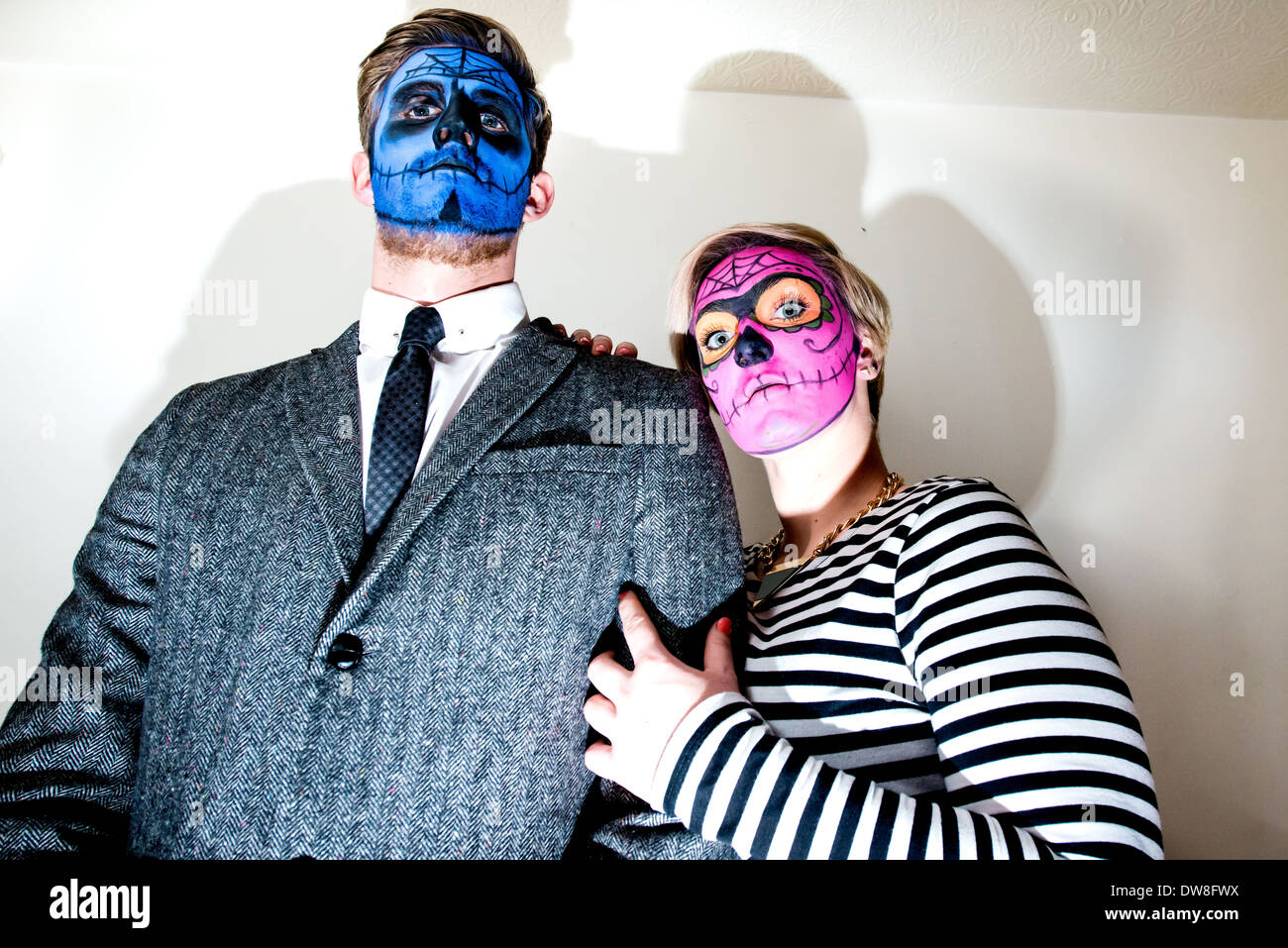 Eine elegant gekleidete junge Paar tragen Zombie Stil Gesicht malen strike eine Horror-Pose für die Kamera. Stockfoto
