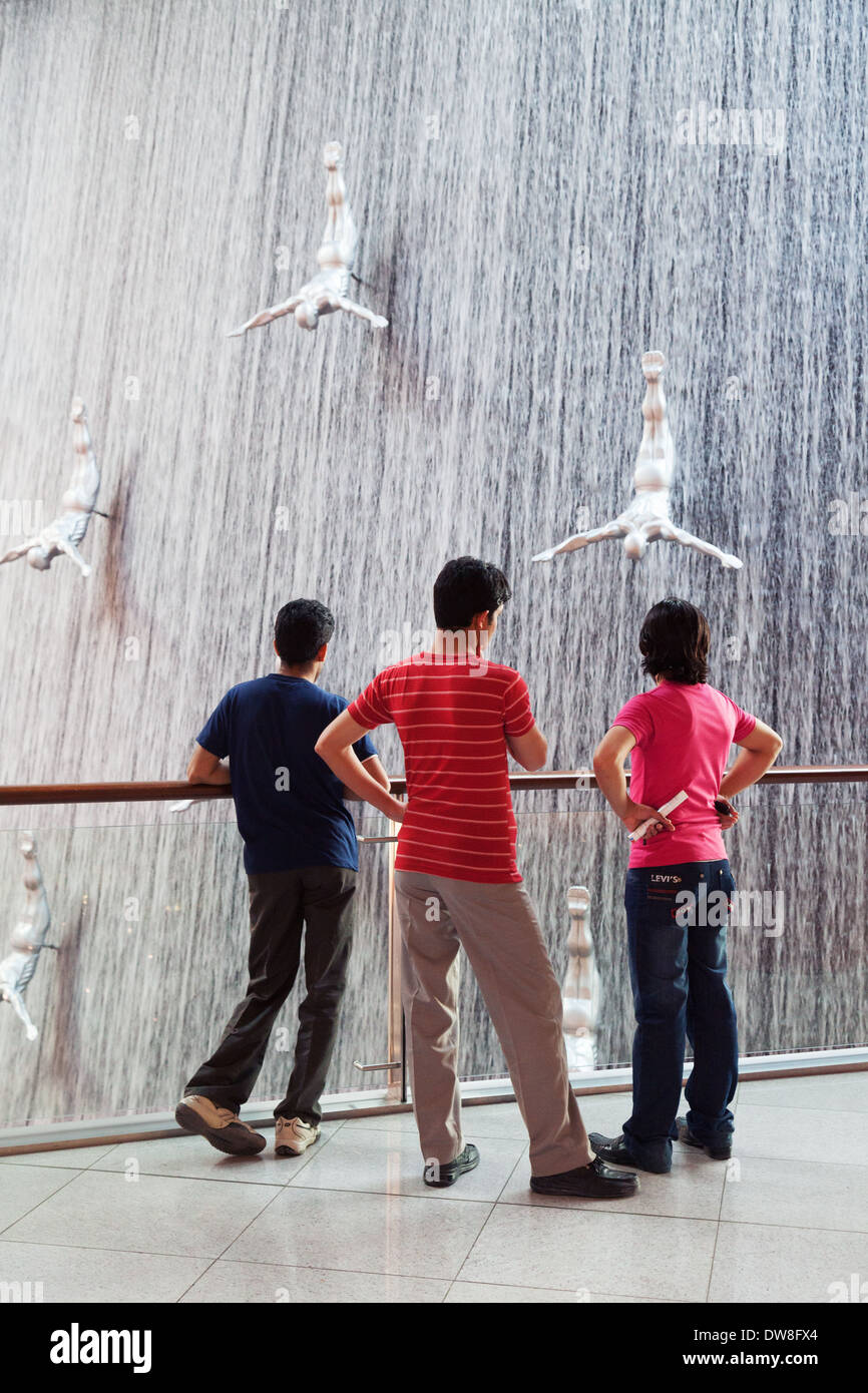 Drei lokale Jugendliche im Teenageralter Blick auf den Wasserfall in der Dubai Mall, Dubai, Vereinigte Arabische Emirate, Vereinigte Arabische Emirate-Nahost Stockfoto