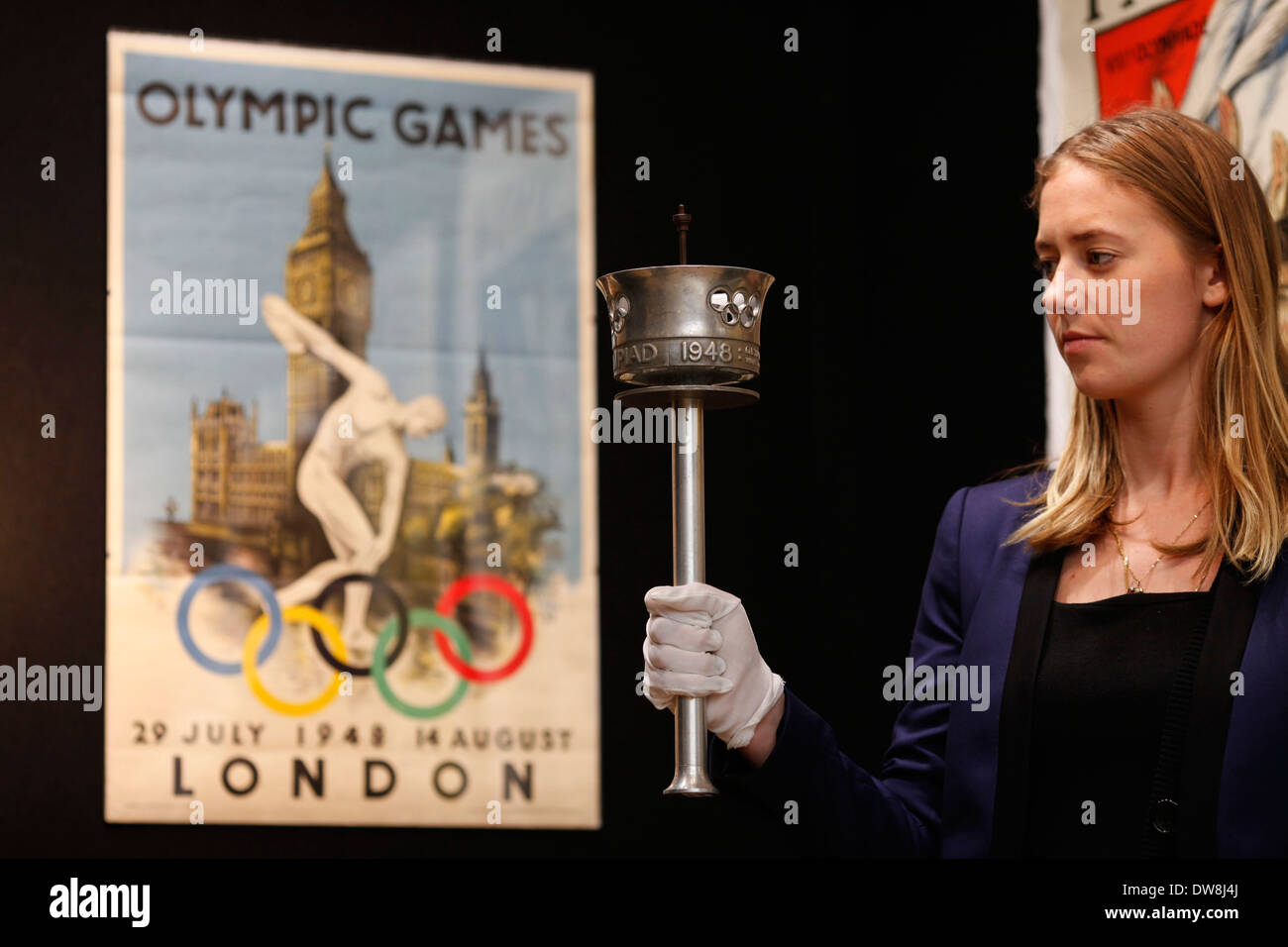 Ein Christie Mitarbeiter posiert mit der Olympischen Fackel 1948 London in London, Großbritannien, 8. März 2012. die Fackel schätzen £1200-1800 Foto von Tal COHEN Stockfoto