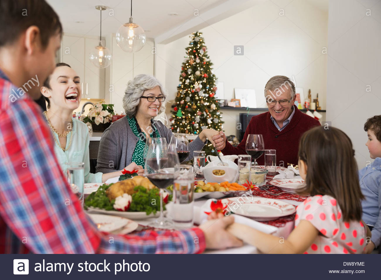 Multi-Generationen-Familie sagen Gnade vor dem Weihnachtsessen Stockfoto