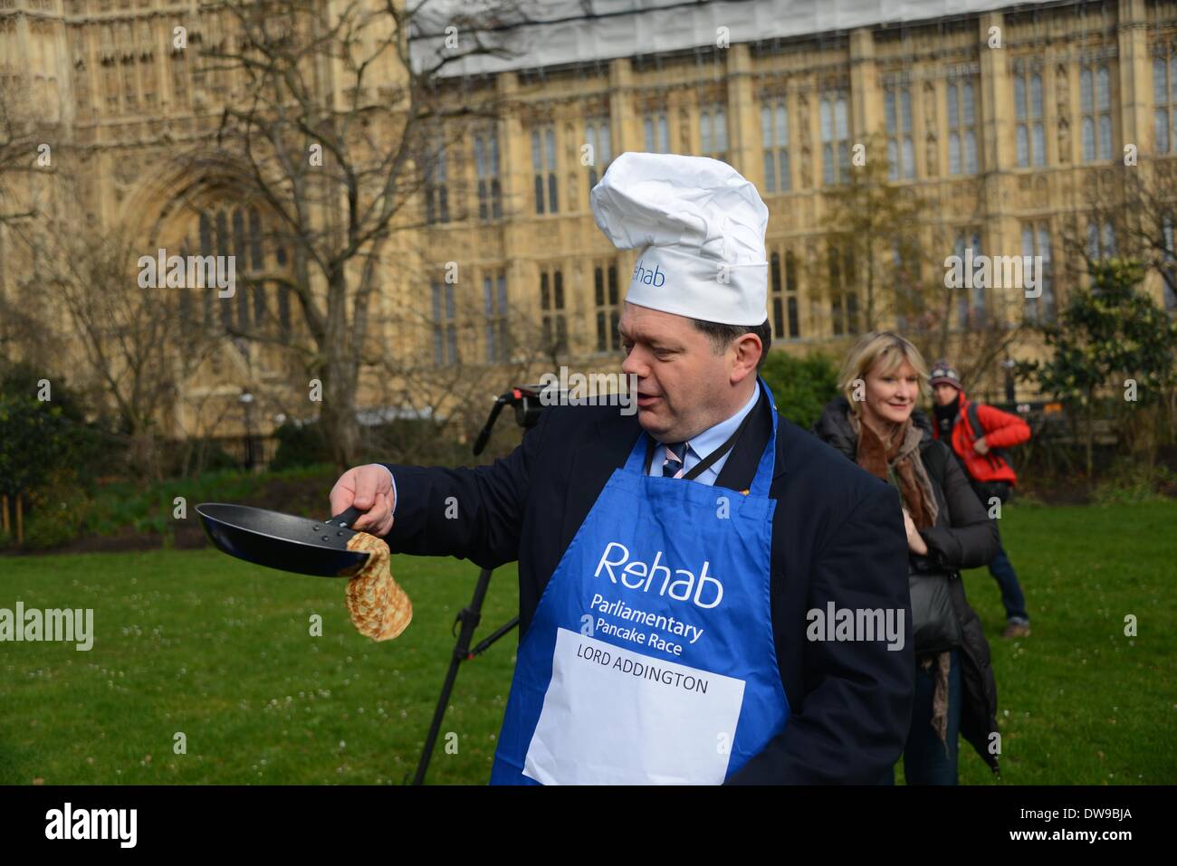 London England, 4. März 2014: Herr Addington Praktiken spiegeln seine Pfannkuchen während der jährlichen parlamentarischen Pancake Race 2014 Credit: siehe Li/Alamy Live News Stockfoto