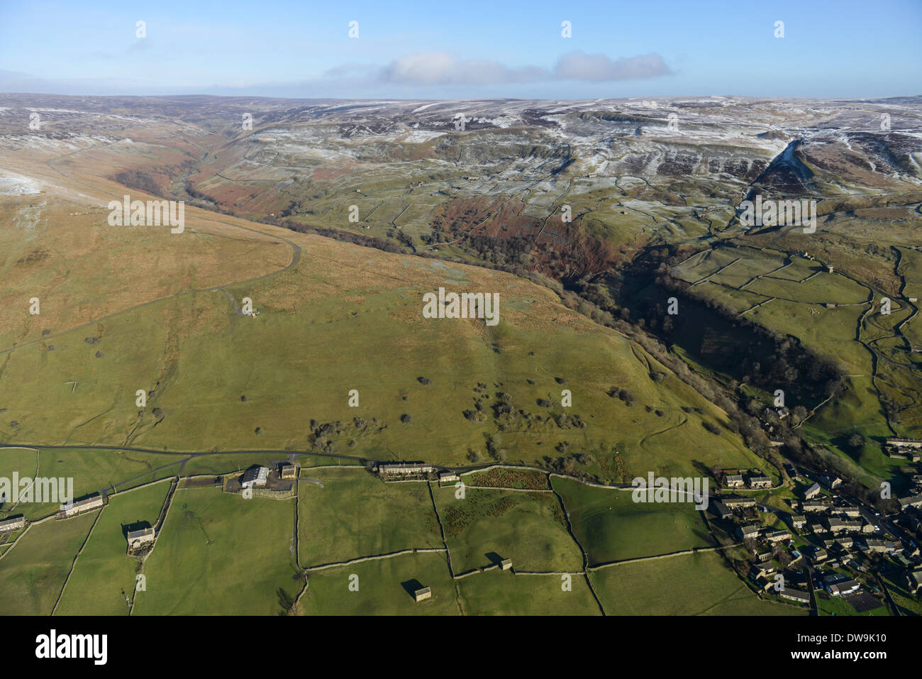 Luftaufnahme zeigt Gunnerside in den Yorkshire Dales im Winter mit verschneiten Gipfeln und ein Tal im Hintergrund Stockfoto