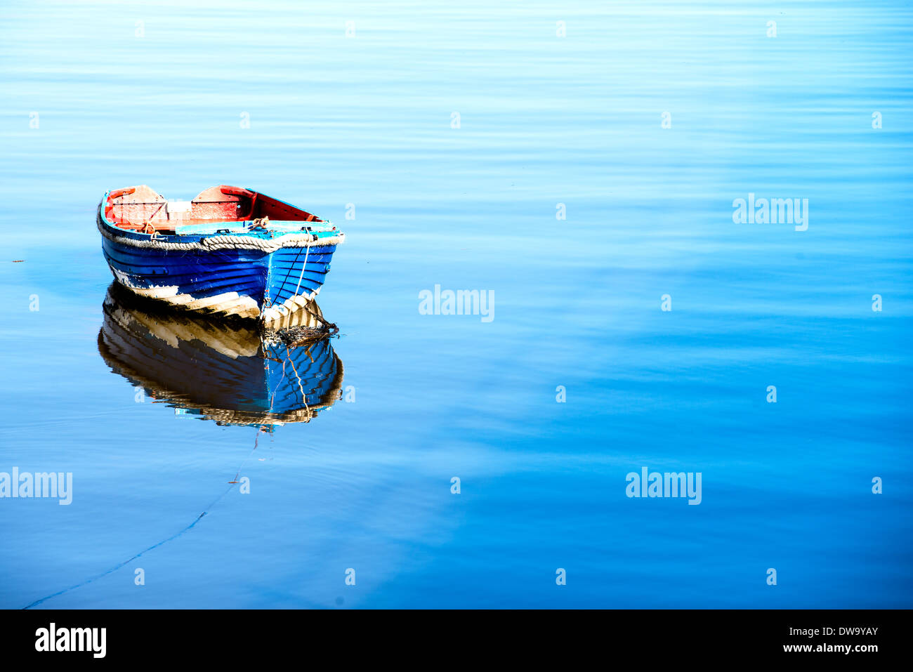 Ein kleines Holzboot mit rot innen Blau spiegelt sich in den Fluss zu tragen bei Sunderland. Stockfoto