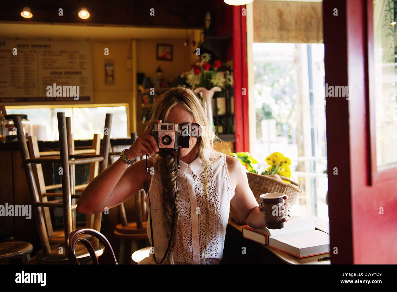 Junge Frau nehmen Foto im café Stockfoto