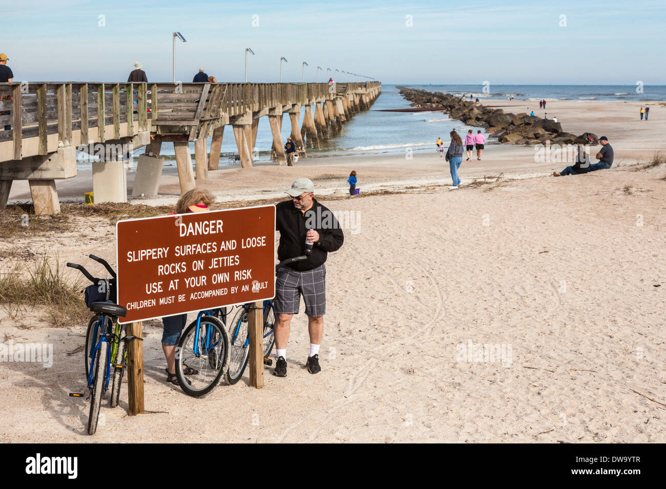 Schild am Fort Clinch Pier und Steg warnt vor rutschigen Oberflächen und lose Felsen Stockfoto