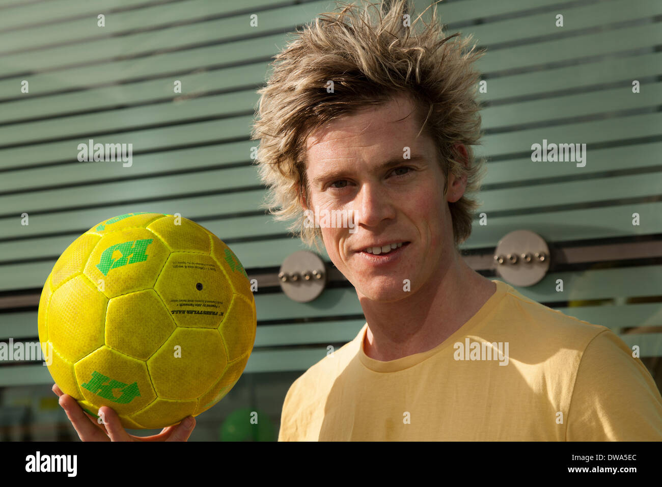 Manchester UK. European Freestyle Fussball Meister John Farnworth, HERR, mit gelben Fußball" Keepy Uppy' Fähigkeiten, Tricks, Spaß, Lifestyle, Fitness, glücklich, Praxis, Erholung, talentierte, Bewegung, Spiel, kicken Fußball, eine Pelé inspirierte Freestyle, in den Straßen in der Nähe der Urbis nationale Fußball-Museum. Wm 100 Tage Countdown Karneval ein Tag der Feierlichkeiten wie Mardi Gras zu Beginn der 100 Tage Countdown bis zum Beginn der diesjährigen WM feiern! John ist ein Fußball-Freestyler und Entertainer, der die vier Guinness World Records einschließlich der meisten rund um die Welten in einer Minute. Stockfoto