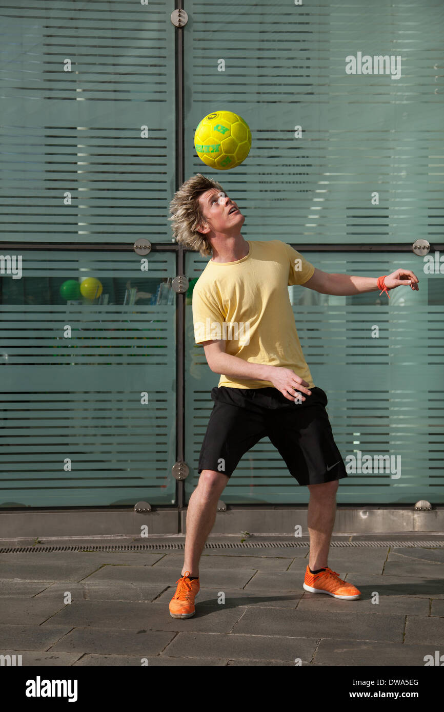 Manchester UK. European Freestyle Fussball Meister John Farnworth, MR, zeigt seine Fußball" Keepy Uppy' Fähigkeiten, Tricks, Spaß, Lifestyle, Fitness, glücklich, Praxis, Erholung, talentierte, Bewegung, Spiel, kicken Fußball, eine Pelé inspirierte Freestyle, in den Straßen in der Nähe der Urbis nationale Fußball-Museum. Wm 100 Tage Countdown Karneval ein Tag der Feierlichkeiten wie Mardi Gras zu Beginn der 100 Tage Countdown bis zum Beginn der diesjährigen WM feiern! John ist ein Fußball-Freestyler und Entertainer, der die vier Guinness World Records einschließlich der meisten rund um die Welten in einer Minute. Stockfoto