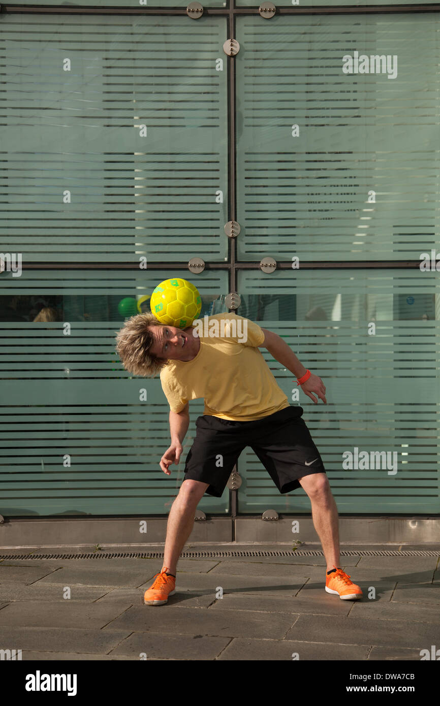 Manchester UK. European Freestyle Fussball Meister John Farnworth, MR, zeigt seine Fußball" Keepy Uppy' Fähigkeiten, Tricks, Spaß, Lifestyle, Fitness, glücklich, Praxis, Erholung, talentierte, Bewegung, Spiel, kicken Fußball, eine Pelé inspirierte Freestyle, in den Straßen in der Nähe der Urbis nationale Fußball-Museum. Wm 100 Tage Countdown Karneval ein Tag der Feierlichkeiten wie Mardi Gras zu Beginn der 100 Tage Countdown bis zum Beginn der diesjährigen WM feiern! John ist ein Fußball-Freestyler und Entertainer, der die vier Guinness World Records einschließlich der meisten rund um die Welten in einer Minute. Stockfoto