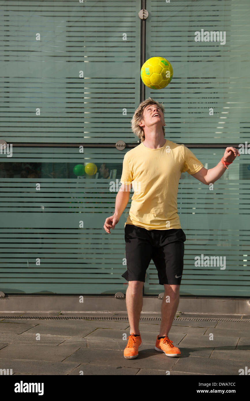 Manchester UK. European Freestyle Fussball Meister John Farnworth, MR, zeigt seine Fußball" Keepy Uppy' Fähigkeiten, Tricks, Spaß, Lifestyle, Fitness, glücklich, Praxis, Erholung, talentierte, Bewegung, Spiel, kicken Fußball, eine Pelé inspirierte Freestyle, in den Straßen in der Nähe der Urbis nationale Fußball-Museum. Wm 100 Tage Countdown Karneval ein Tag der Feierlichkeiten wie Mardi Gras zu Beginn der 100 Tage Countdown bis zum Beginn der diesjährigen WM feiern! John ist ein Fußball-Freestyler und Entertainer, der die vier Guinness World Records einschließlich der meisten rund um die Welten in einer Minute. Stockfoto