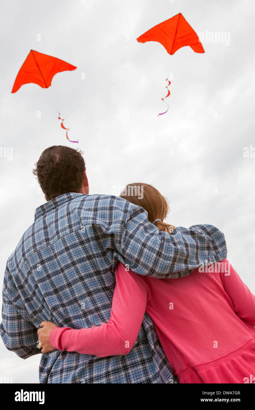 Beziehung Probleme Konzept Foto des Mannes & Frau paar fliegen einen roten Drachen jeweils in verschiedene Richtungen Stockfoto