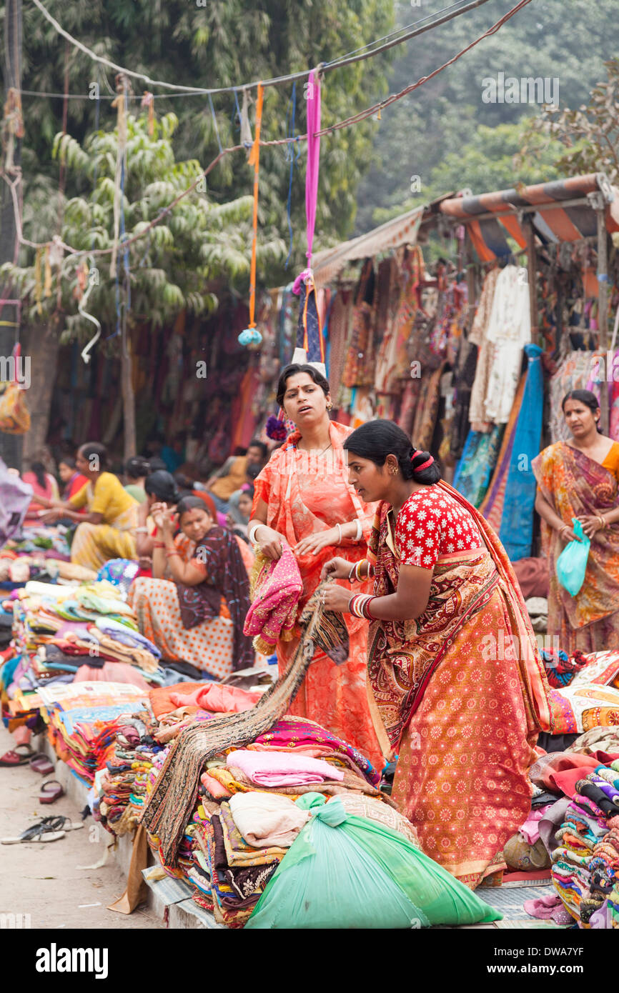 Indische Frauen gekleidet in traditionellen bunten Saris, bunte Stoffen in einem lokalen Markt am Straßenrand verkaufen Stockfoto