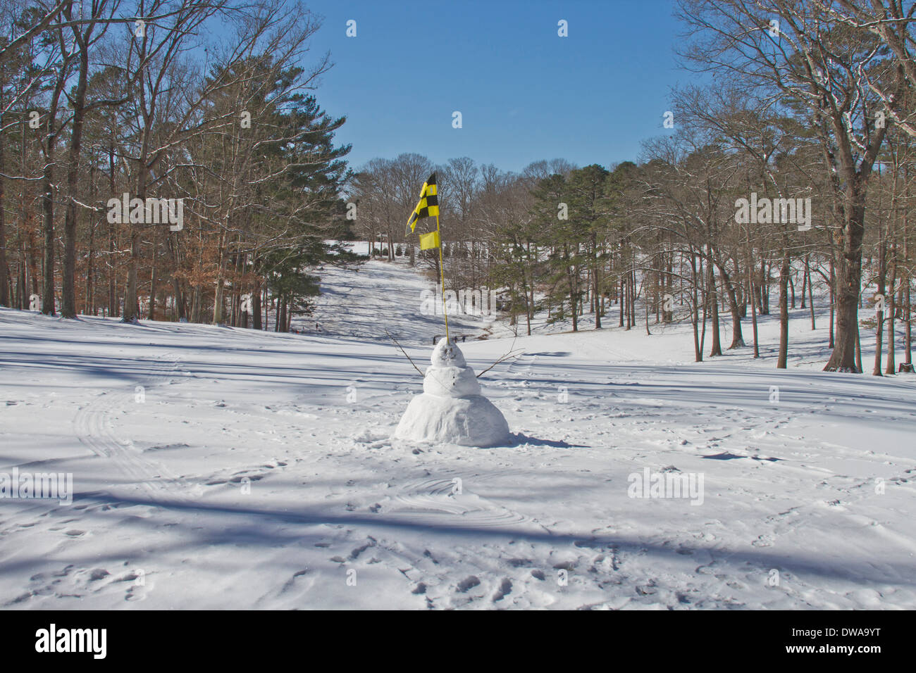 Ein Schneemann mit einem Golf Flagge in seinem Kopf begrüßen Sie auf einem verschneiten Golfplatz Stockfoto