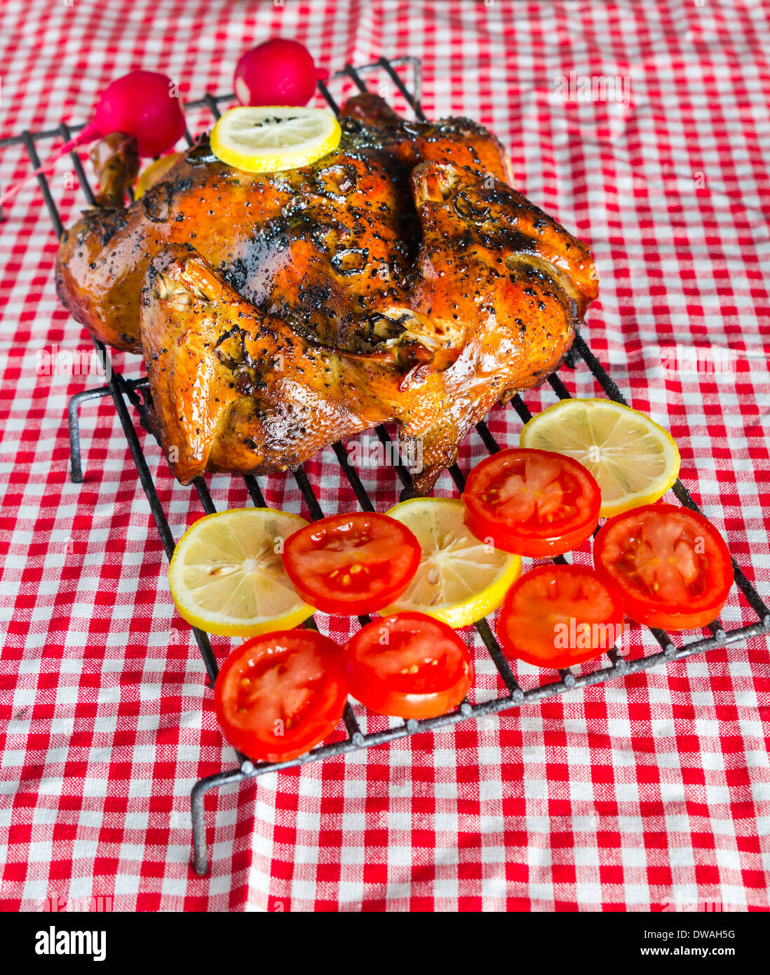 Geräuchertem Huhn auf roten Tischdecke Stockfoto