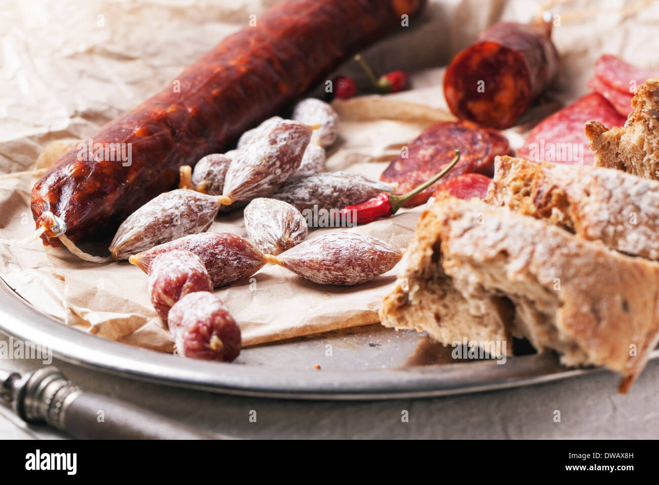 Satz von Salami Wurst mit frischem Brot und red hot Chili Peppers auf Vintage Tablett serviert Stockfoto