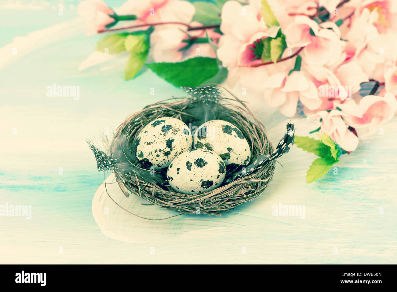 Oster-Deko mit Blumen und Eiern im Nest. Retro-Stil getönten Bild Stockfoto