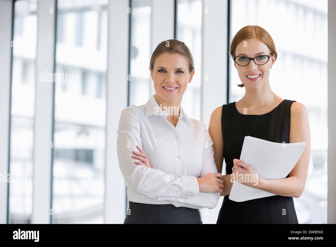 Porträt von zuversichtlich Geschäftsfrauen mit Dokumenten in office Stockfoto