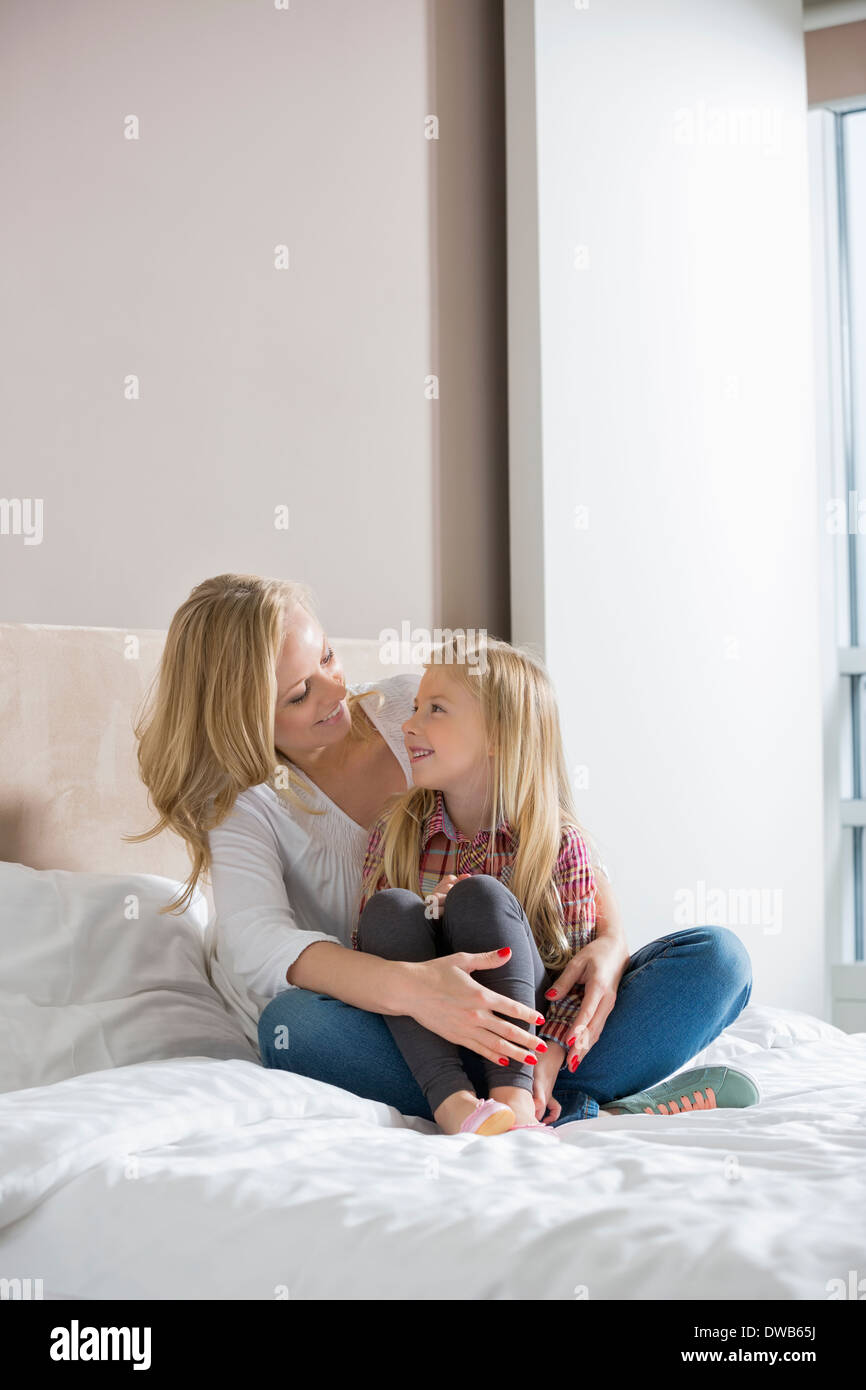 Glückliche Frau und Tochter sahen einander im Schlafzimmer Stockfoto