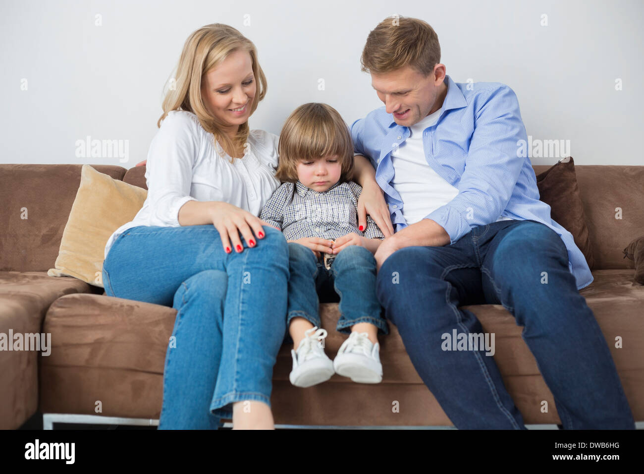 Eltern sitzen mit traurigen Sohn zu Hause auf sofa Stockfoto