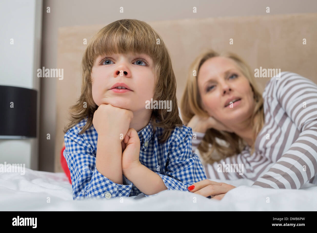 Nachdenkliche junge mit Mutter im Bett Stockfoto