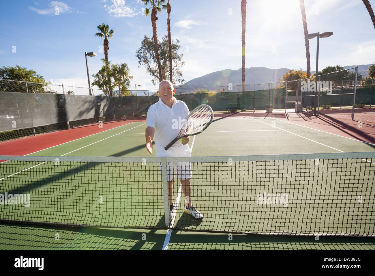 Porträt von senior Tennisspieler bietet Handshake auf Platz Stockfoto