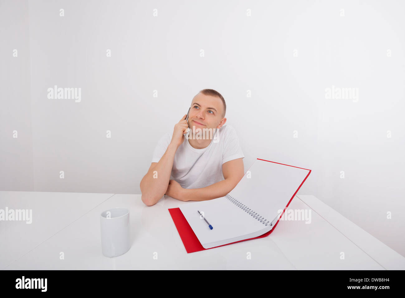 Nachdenklich Geschäftsmann smart Telefon am Schreibtisch Stockfoto