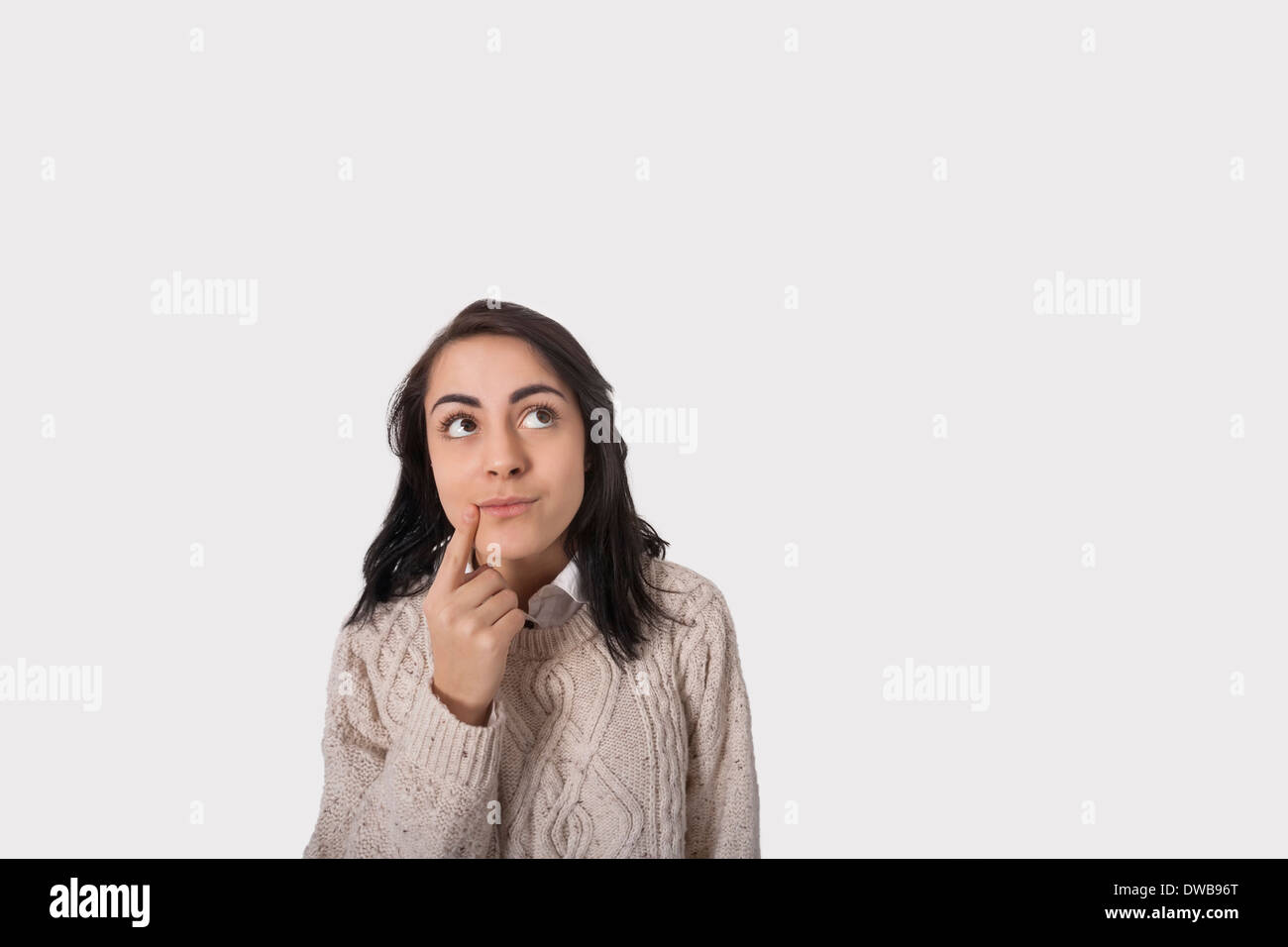 Nachdenklich Geschäftsfrau vor grauem Hintergrund Stockfoto
