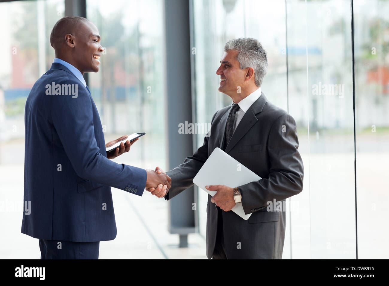 zwei fröhliche Geschäftsmann Handshake im Konferenzsaal Stockfoto