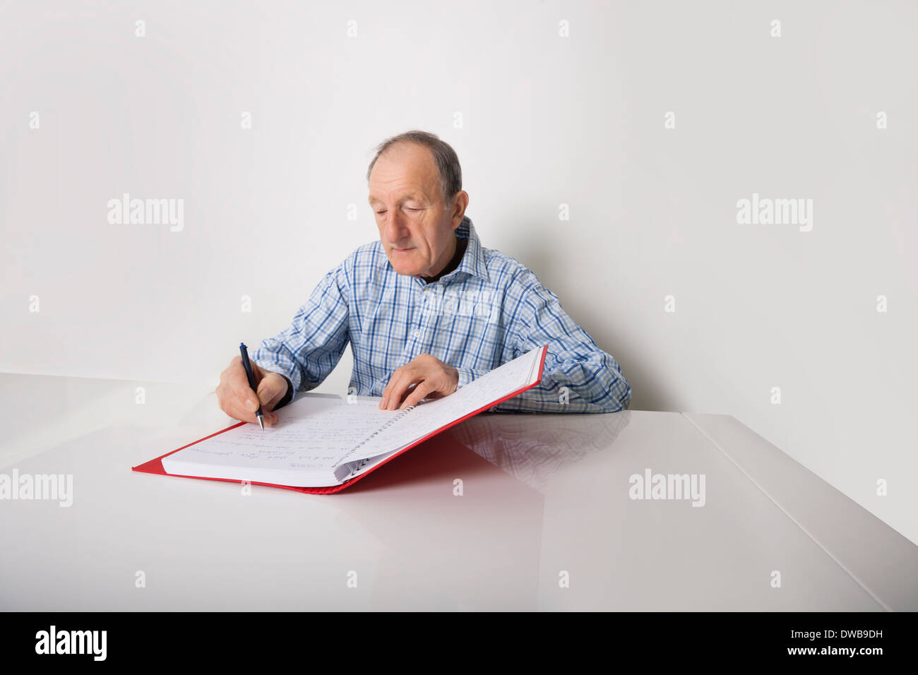 Leitenden Geschäftsmann schreiben in Datei am Schreibtisch Stockfoto