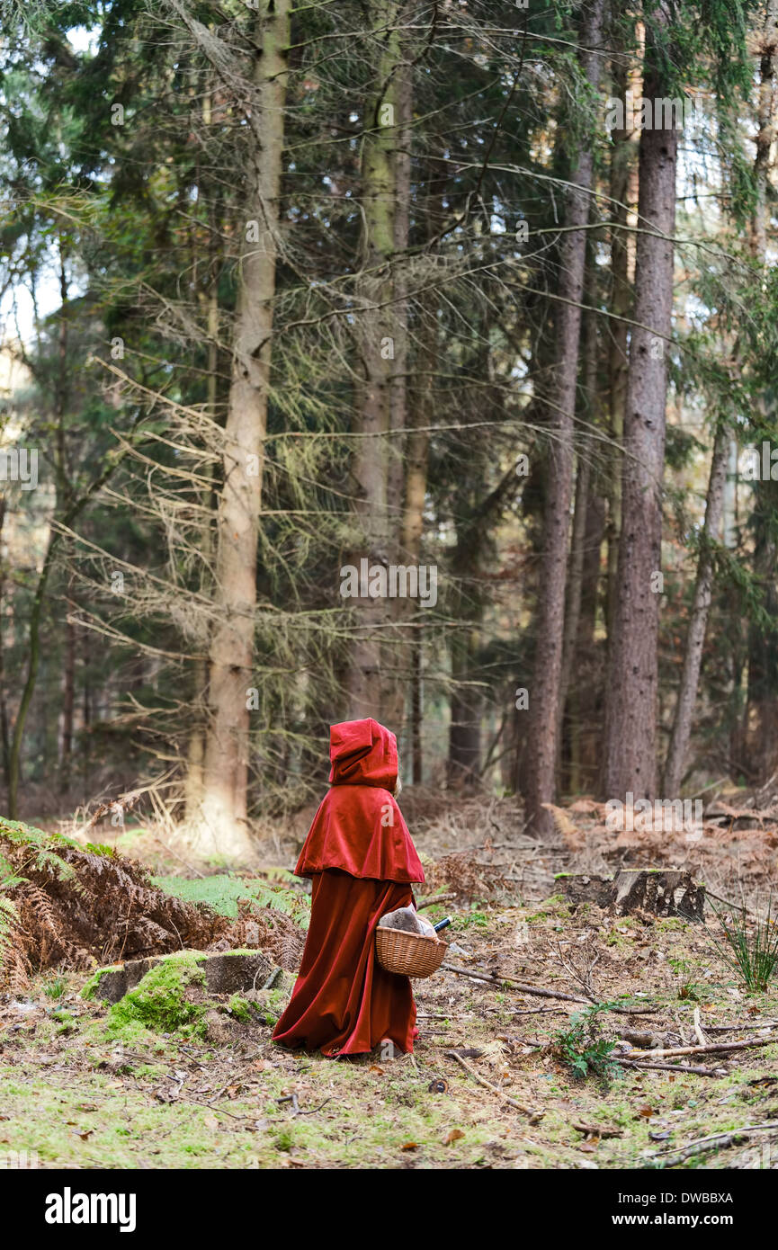 Kleine Mädchen Maskerade als Red Riding Hood steht im Walde Stockfoto