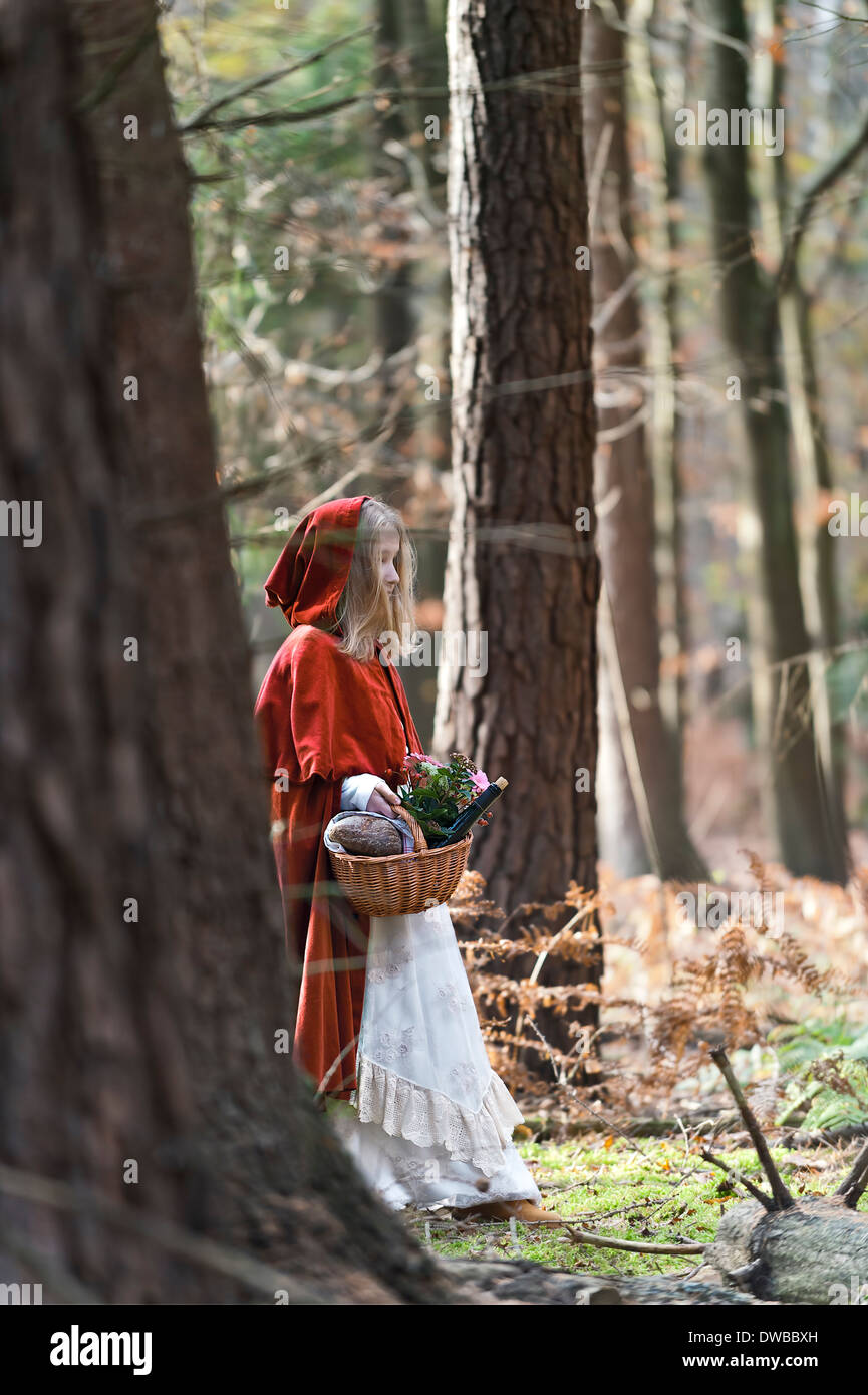 Mädchen-Maskerade als Red Riding Hood steht im Walde Stockfoto