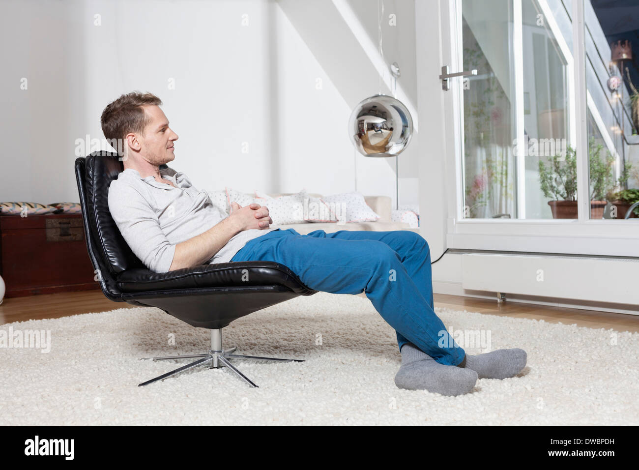 Mann zu Hause entspannen im Sessel Stockfoto