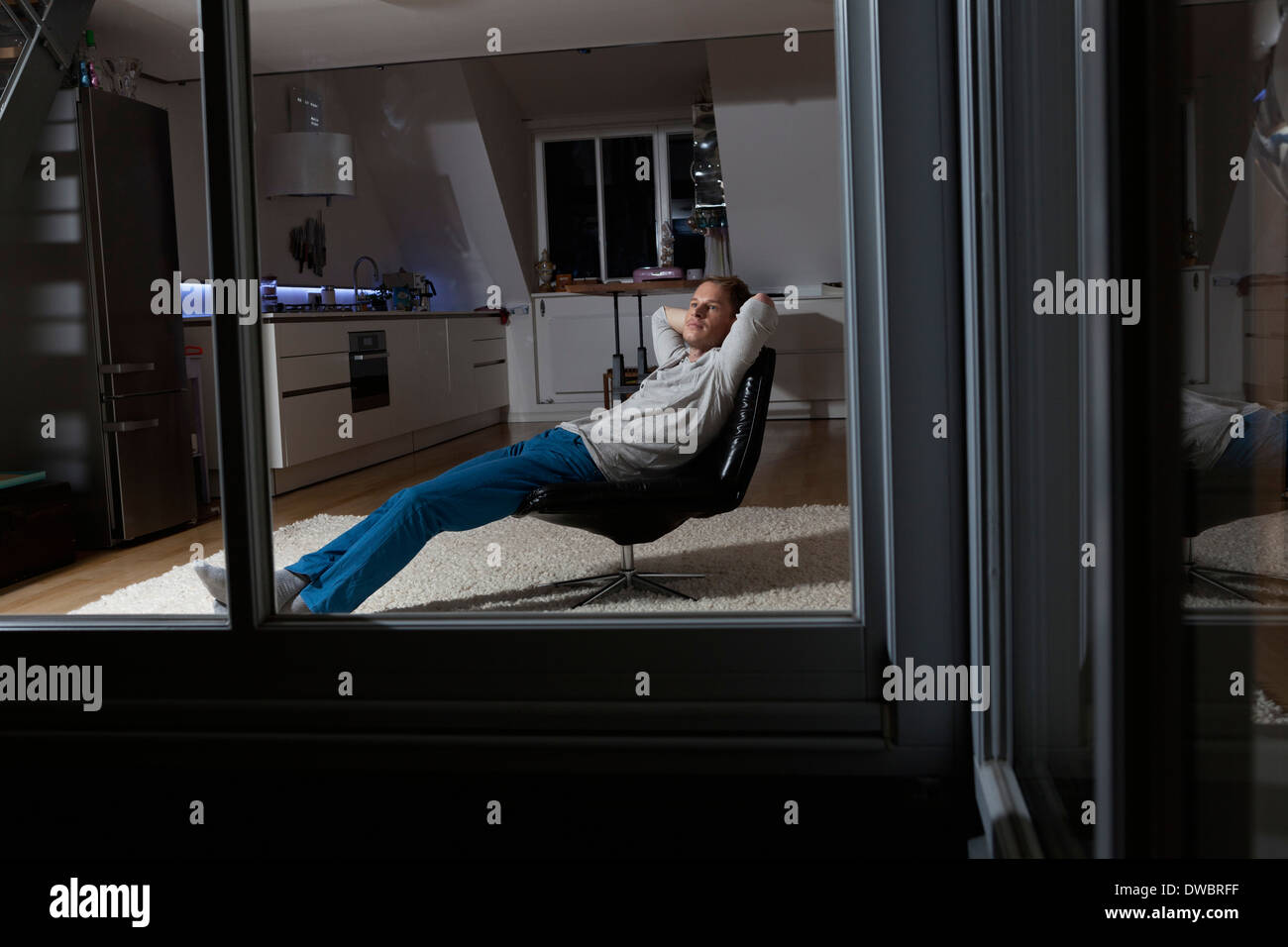 Mann zu Hause gemütlich abends im Sessel Stockfoto