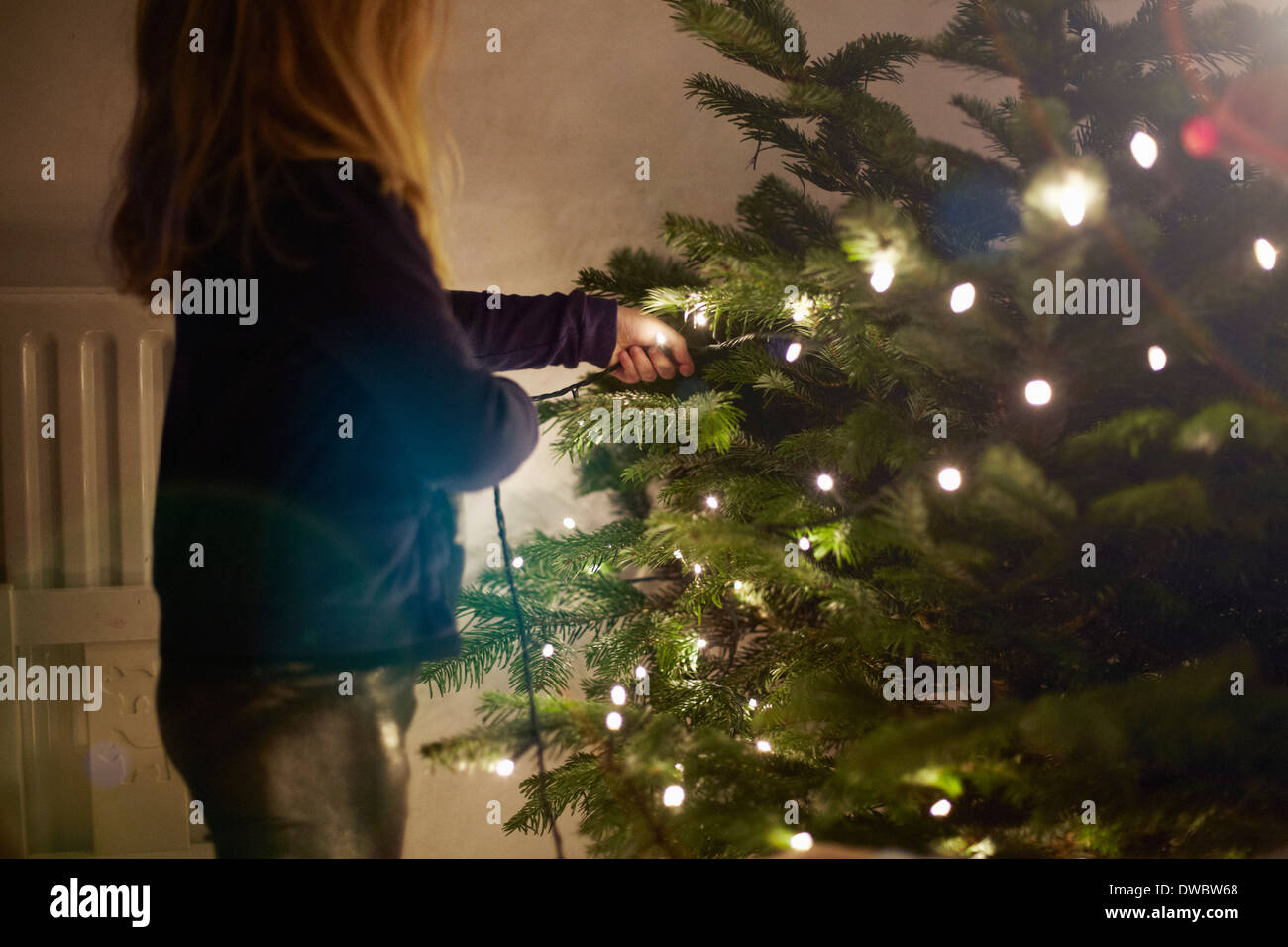 Junges Mädchen ziehen an Weihnachtsbeleuchtung Stockfoto