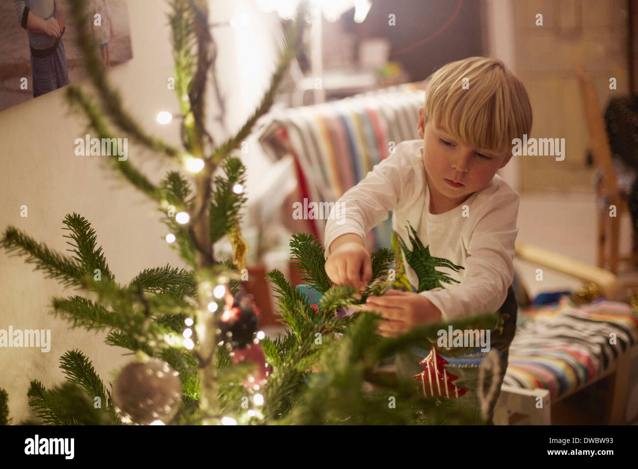 Kleiner junge Baum zu Weihnachten dekorieren Stockfoto