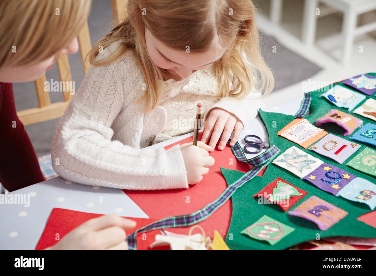 Mutter und Tochter machen Adventskalender am Küchentisch Stockfoto