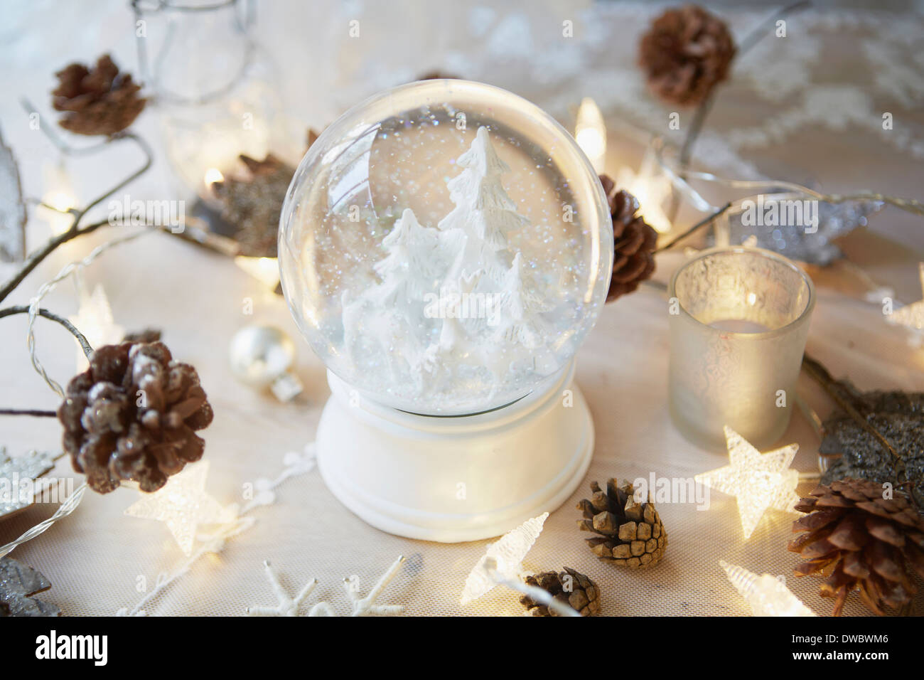 Weihnachtstisch mit Schnee Globus und Tannen Zapfen Stockfoto