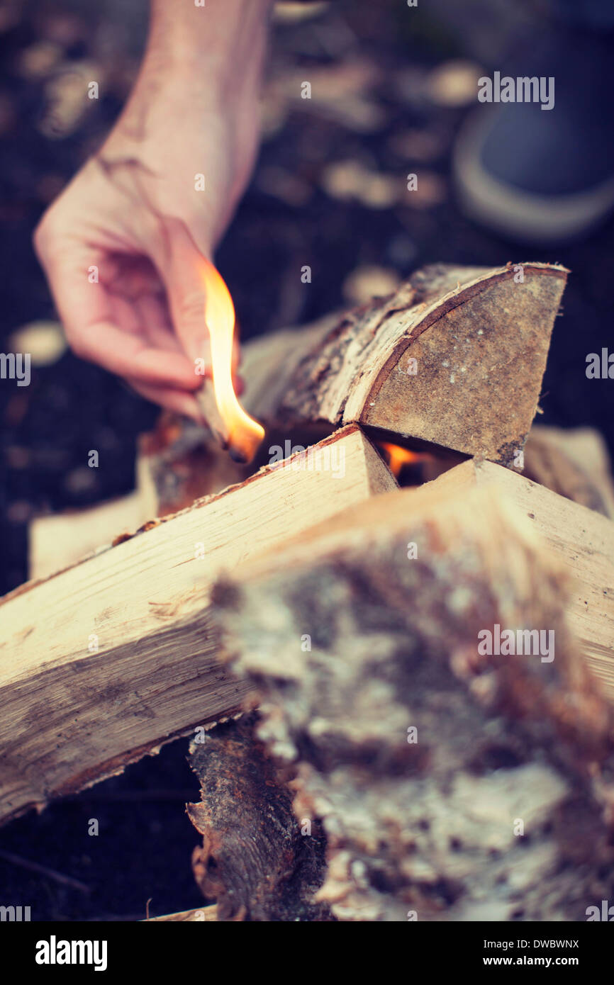Mannes Hand zündenden Lagerfeuer Stockfoto