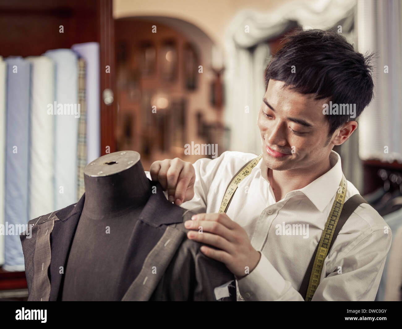 Lehrling Schneider pinning Kleidungsstück im traditionellen Schneider shop Stockfoto