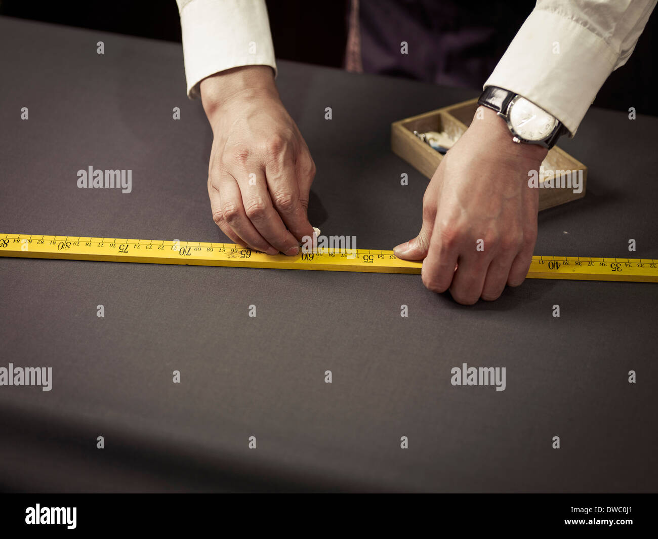 Maßgeschneiderte Kreidung Messungen am Tisch in traditionellen Schneider shop Stockfoto