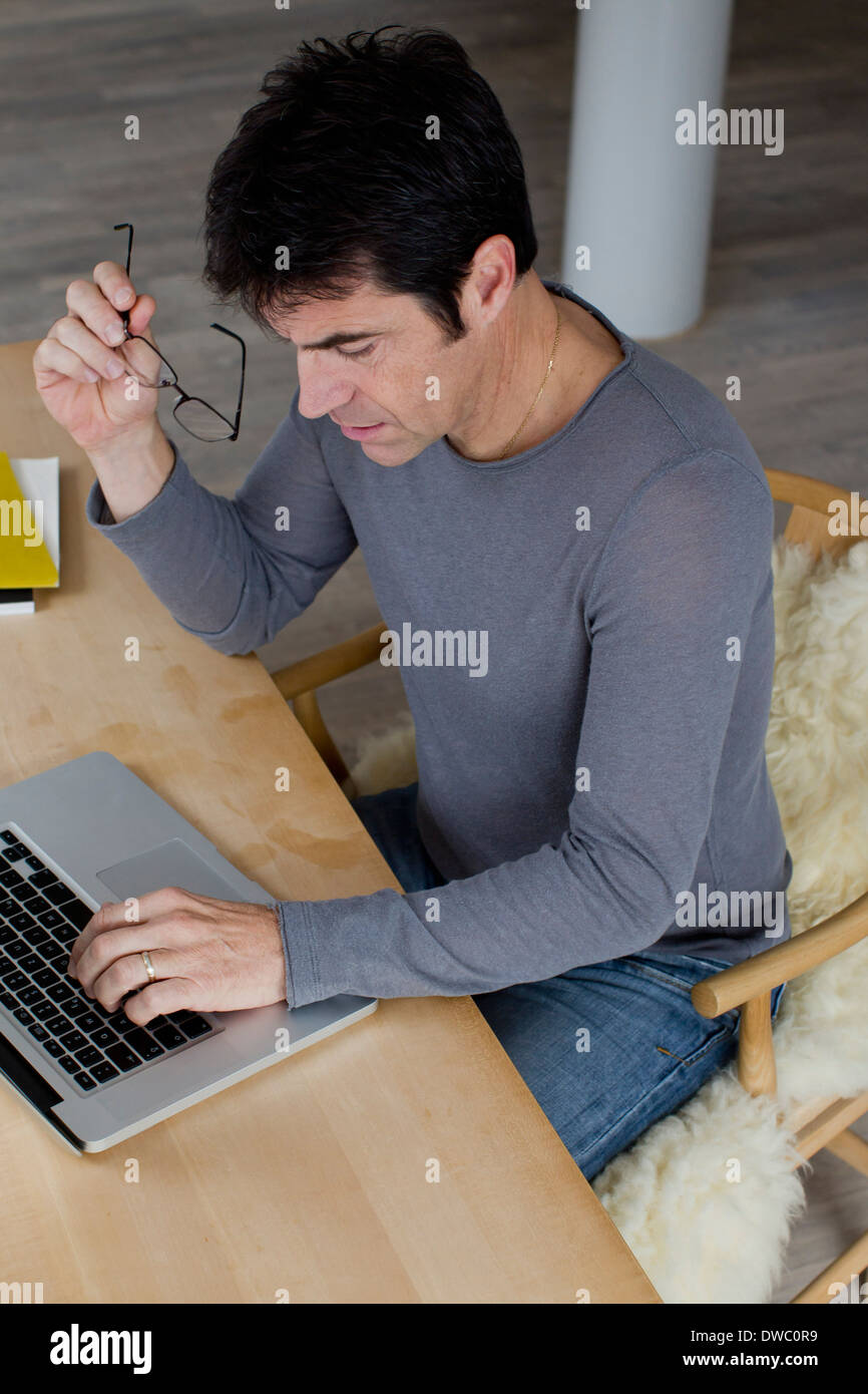 Reife Geschäftsmann einen Laptop zu Hause arbeiten Stockfoto
