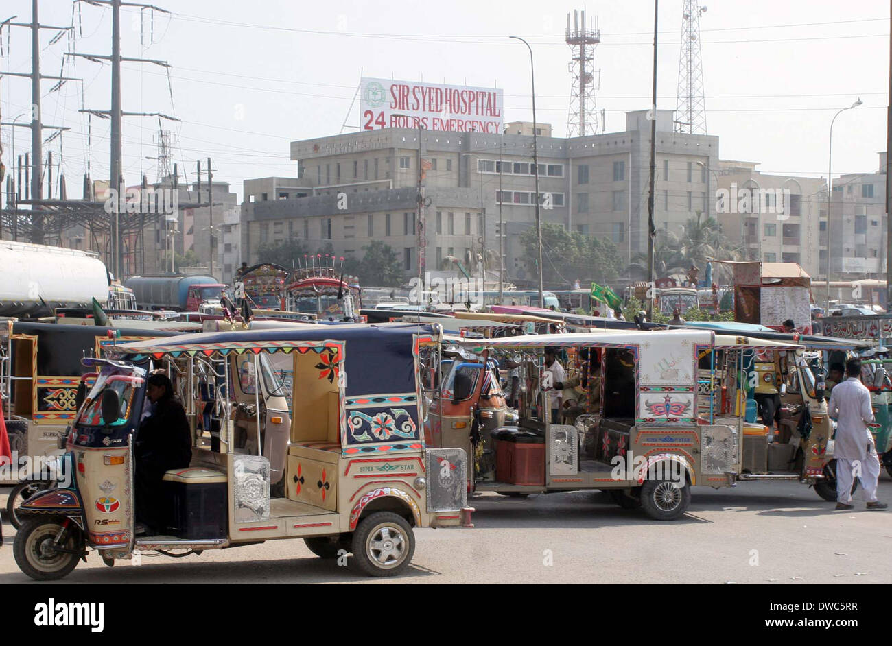 Die zwölf Sitze Auto Rikschafahrer, die gegen Gerichtsbeschluss CNG-Autos, bei KPT Interchange Qaiyyumabad Verbot protestierten verursacht stark befahrenen Marmelade in Umgebung, wie die Polizei Schlagstock kostenlos und Antenne feuern verwendet, um Demonstranten in Karachi auf Mittwoch, 5. März 2014 zu zerstreuen. Stockfoto