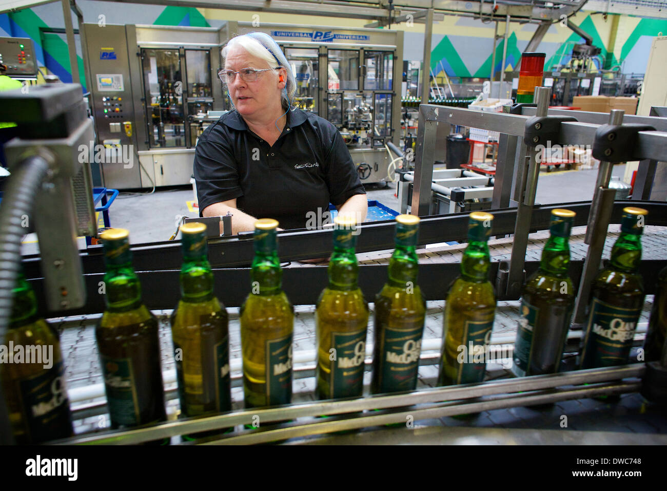 Ein Produktionsmitarbeiter überprüft Whisky-Flaschen in der Abfüllanlage von William Grant & Sons in Bellshill. Stockfoto