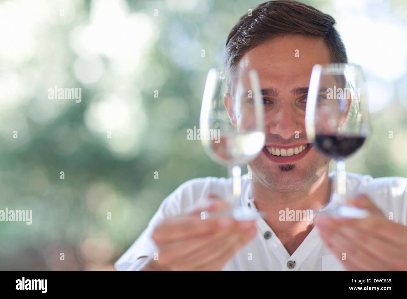 Junge männliche Kellner hält Gläser Rot- und Weißweine Stockfoto Junge männliche Kellner hält Gläser Rot- und Weißweine Stockfoto
