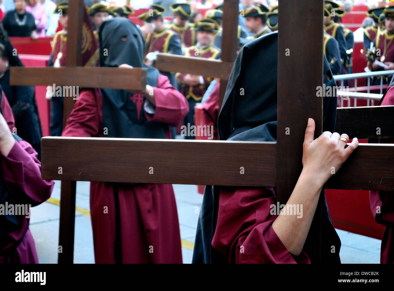 Büßer tragen große Kreuze in einer Prozession der Karwoche. Stockfoto