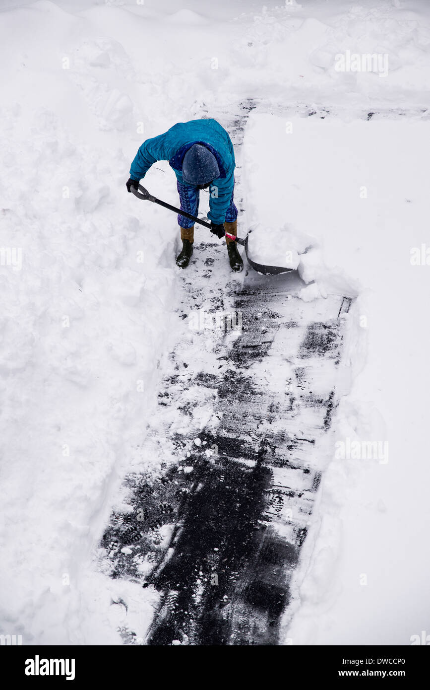 Erwachsenen Schneeschaufeln nach Wintersturm. Stockfoto