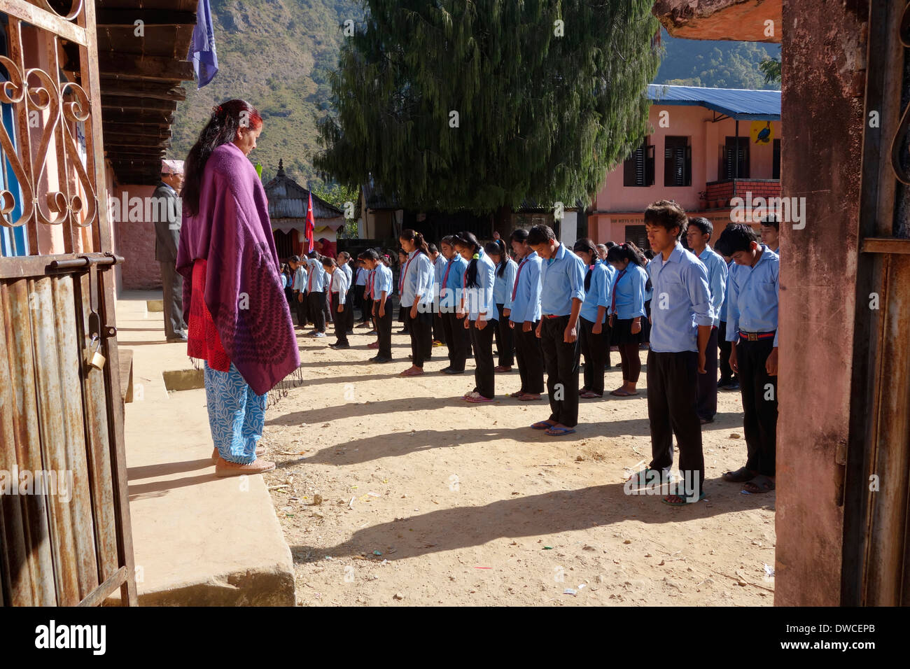 Studenten stehen auf einem Schulhof, während die nepalesischen Nationalhymne gespielt wird, Bahundanda, Nepal Stockfoto