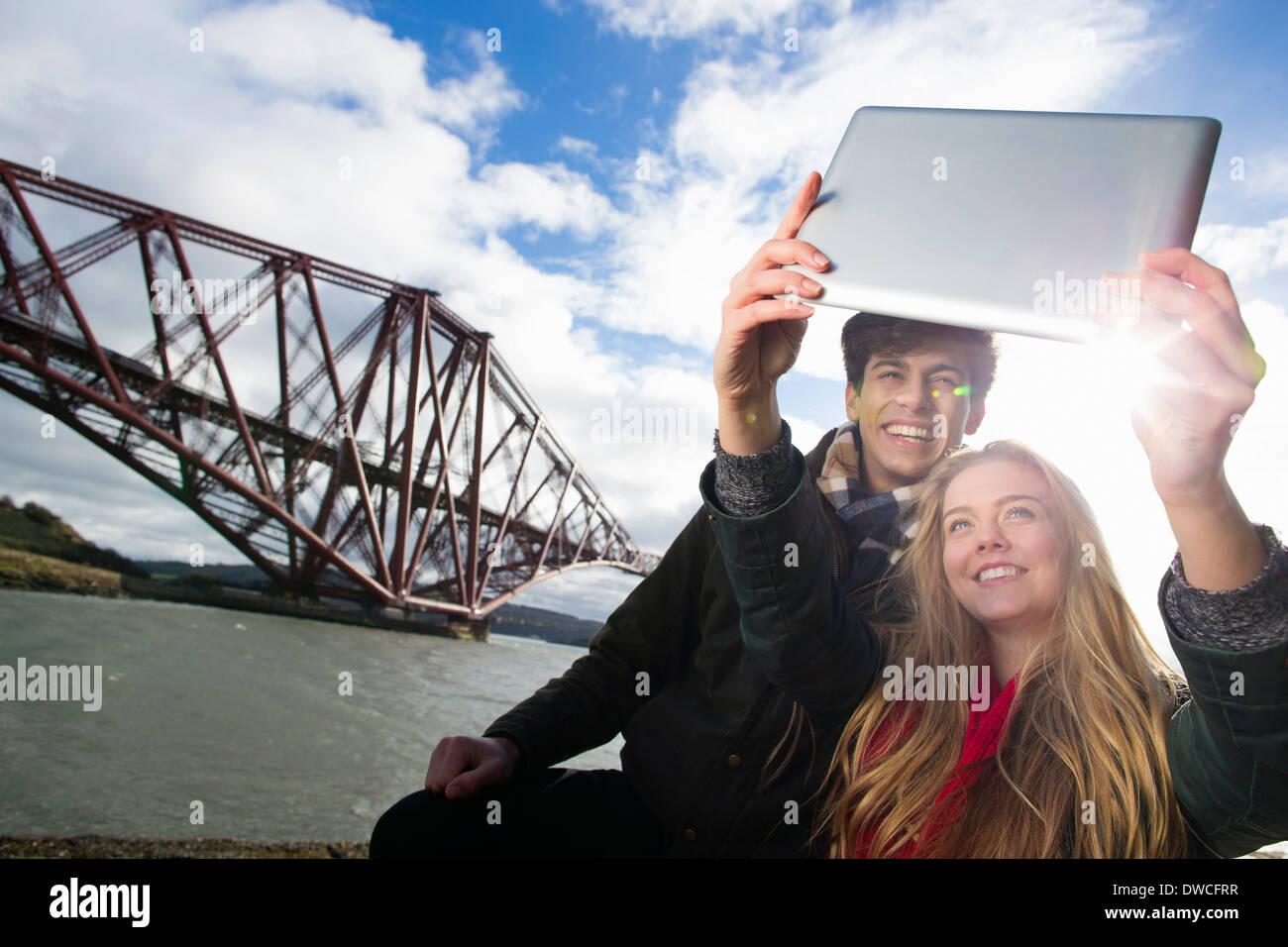 Ein junges Paar posieren vor die Forth Rail Bridge in Queensferry, in der Nähe von Edinburgh, Schottland Stockfoto