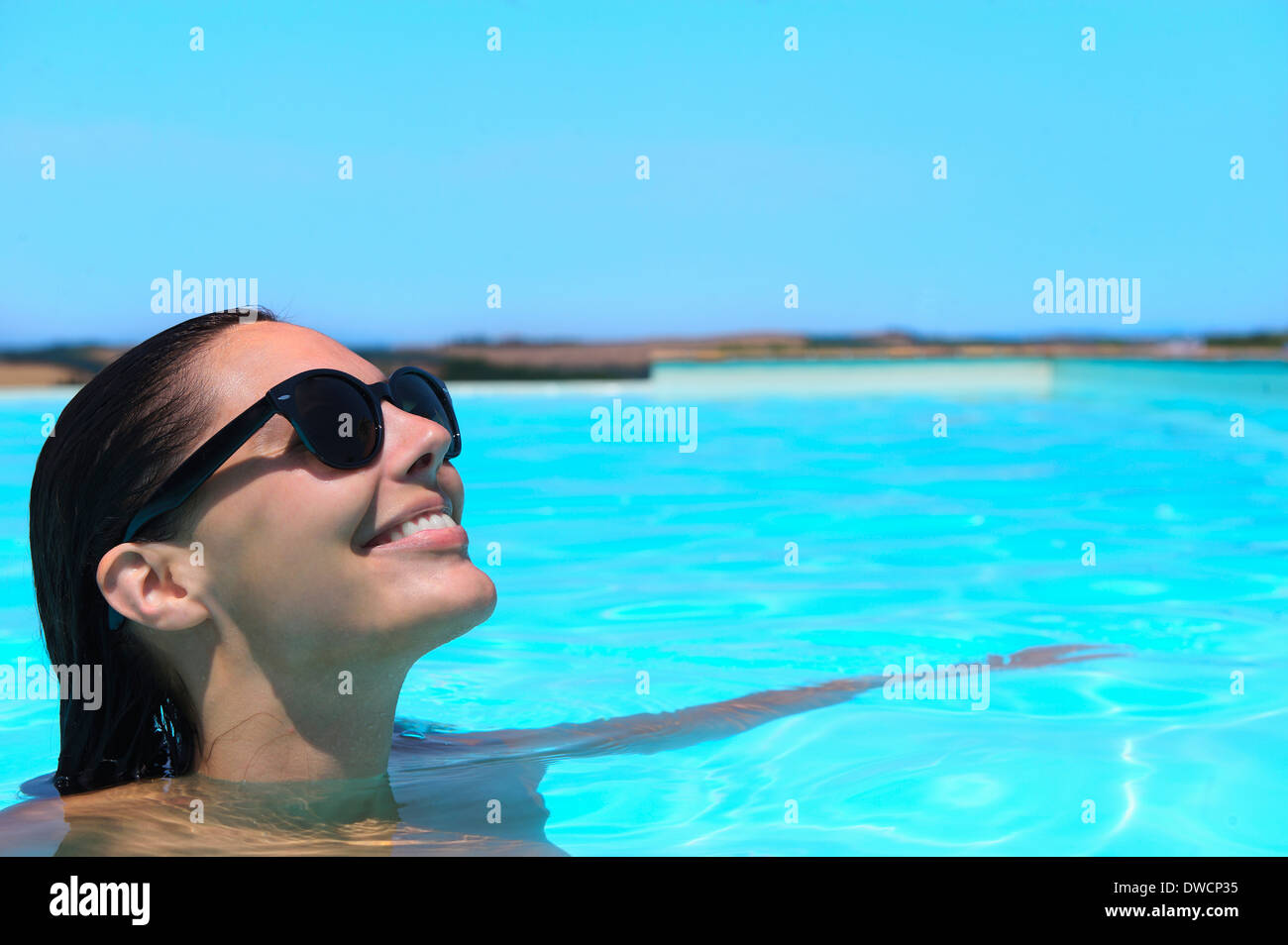 Mitte Erwachsene Frau mit Sonnenbrille entspannen im pool Stockfoto