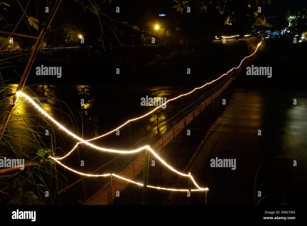 Saisonale Bambus-Brücke über den Fluss Nam Kahn beleuchtet in der Nacht, Luang Prabang, Laos. Stockfoto